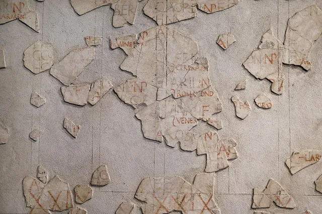 Fragments of a painted Roman wall calendar, the Fasti Antiates, with day letters and markings in red and black.